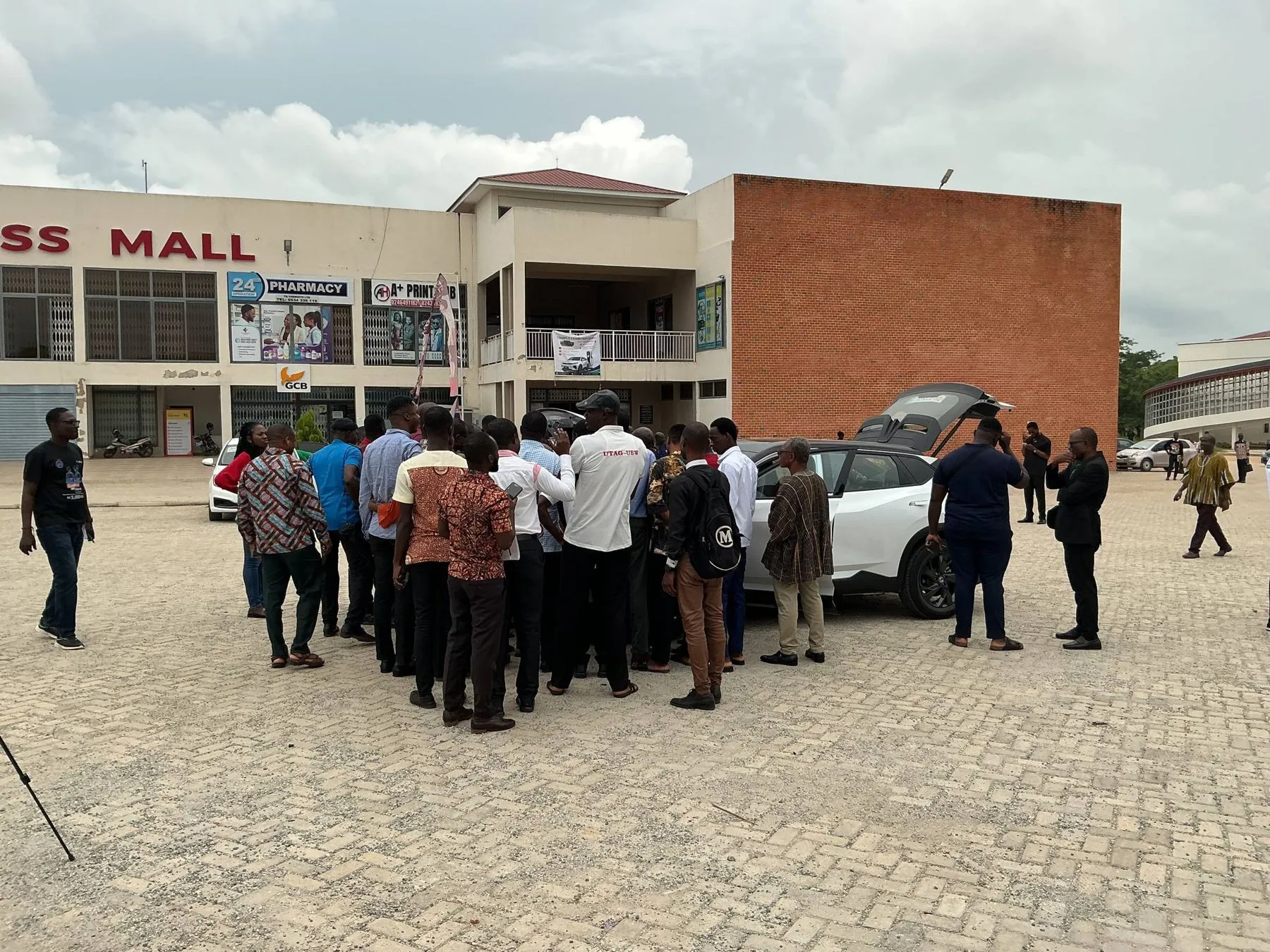 Visitors gathered around an electric car outside GUSS Mall at the UEW exhibition