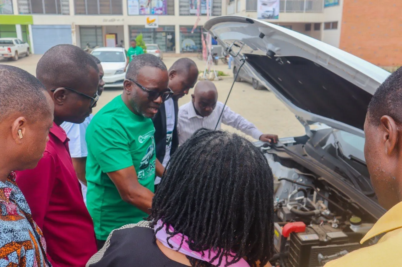 Visitors and a GSI team member looking at the motor of an electric car at the UEW exhibition