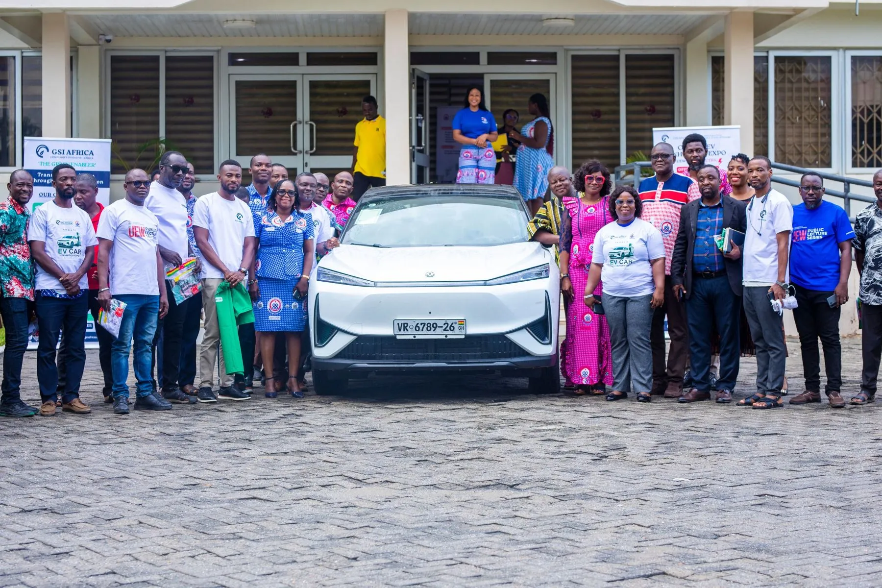 UEW staff and the GSI team gathered around an electric SUV at the launch